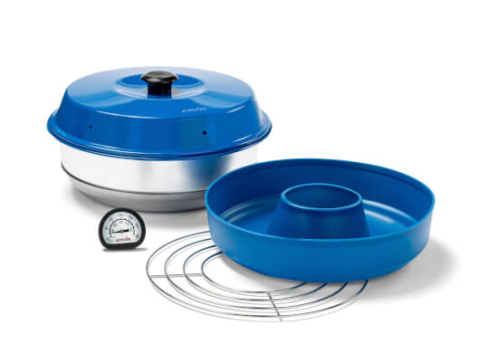 Das Omnia Marine Kit, ein tragbarer Ofen bestehend aus einem blauen Deckel mit schwarzem Griff, einer Aluminium-Basis, einer blauen Backform mit zentraler Öffnung, einem Metallrost und einem Thermometer. Ideal für den Einsatz auf Booten, Campingausflügen und anderen Outdoor-Abenteuern.