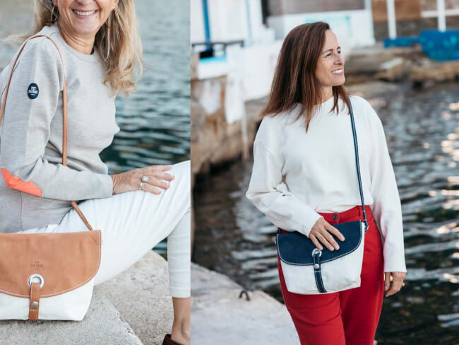 Twee vrouwen bij het water met stijlvolle crossbody-tassen van 727 Sailbags, gemaakt van gerecyclede zeilen.
