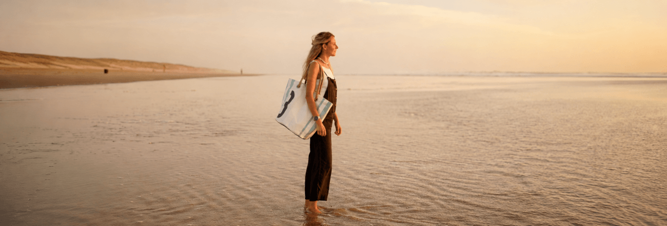 Vrouw met een 727 Sailbags tas op het strand